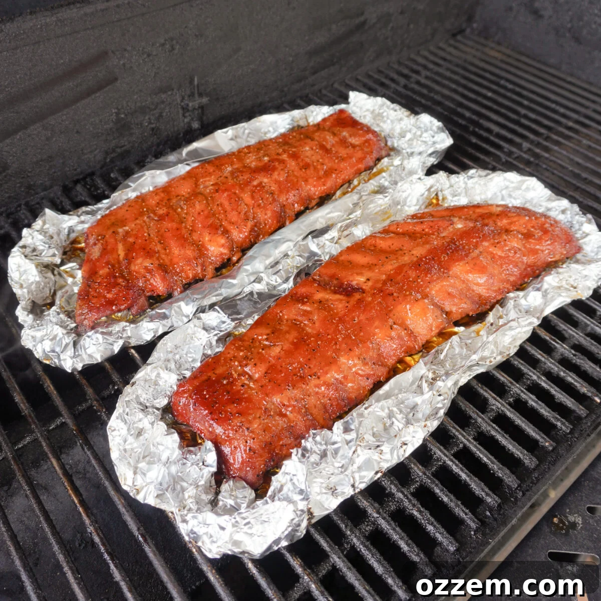 Smoked ribs being brushed with peach bourbon BBQ sauce.