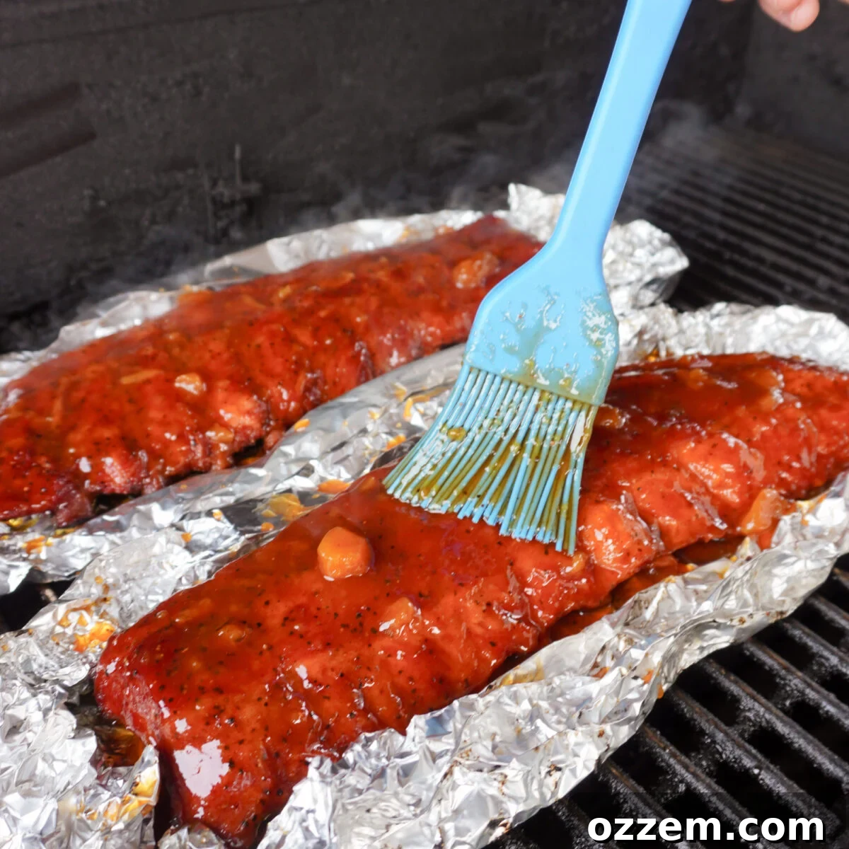 A rack of peach bourbon smoked ribs generously coated in sauce.