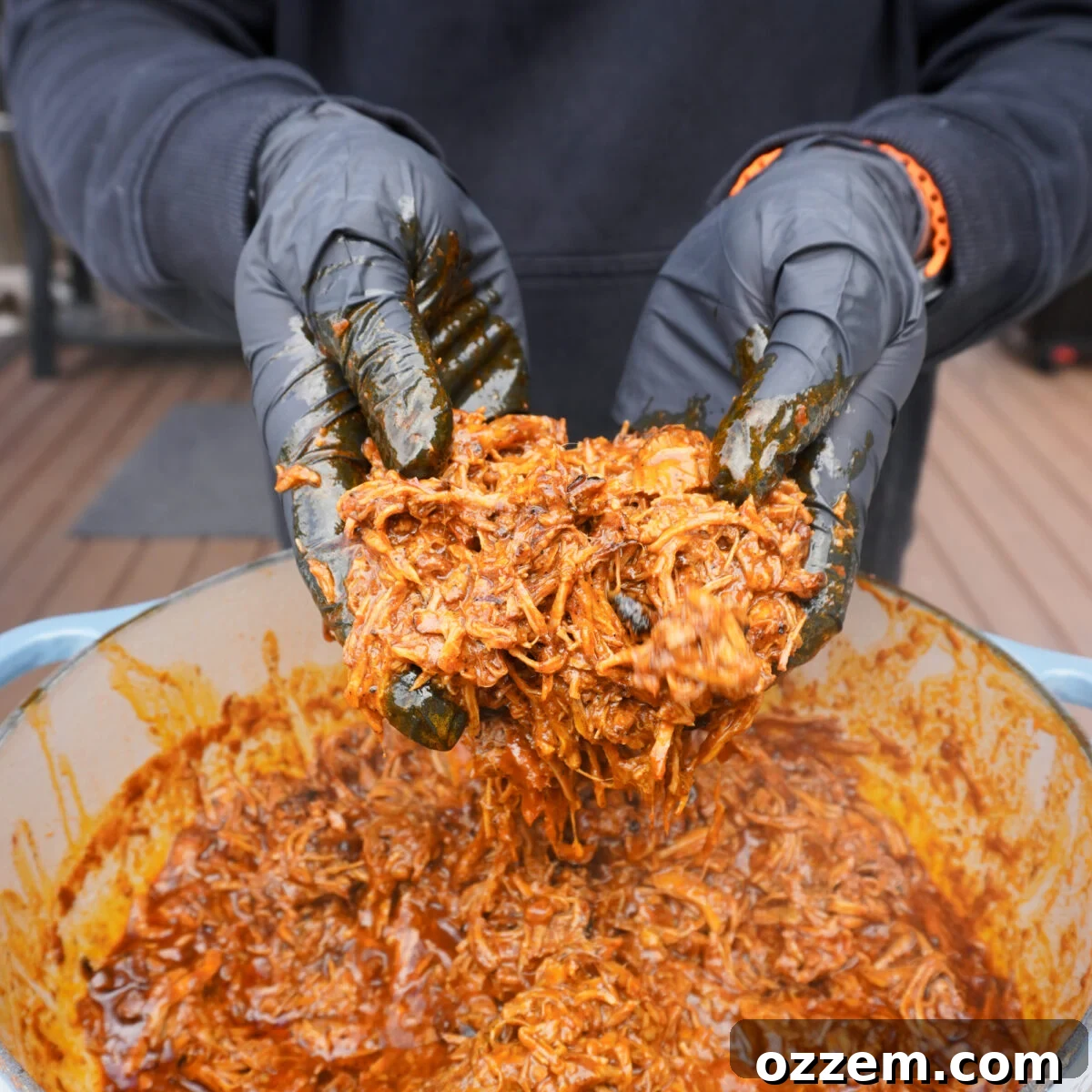 Shredded pork in adobo sauce inside a Dutch oven.