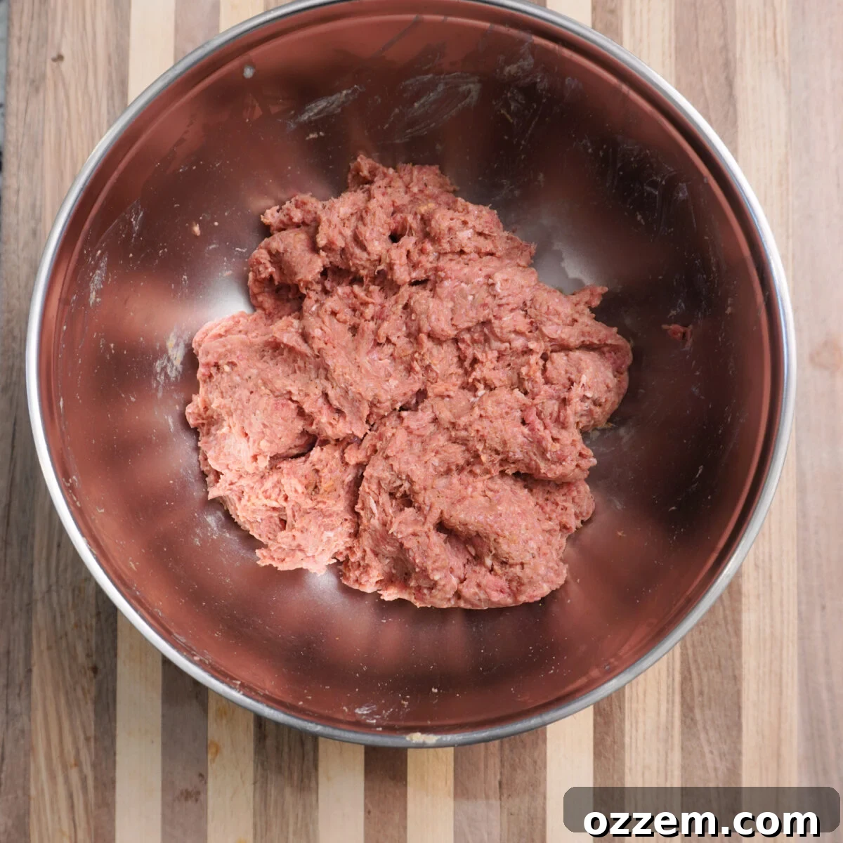 Close-up of seasoned ground beef kebab mixture in a large mixing bowl, ready for shaping.