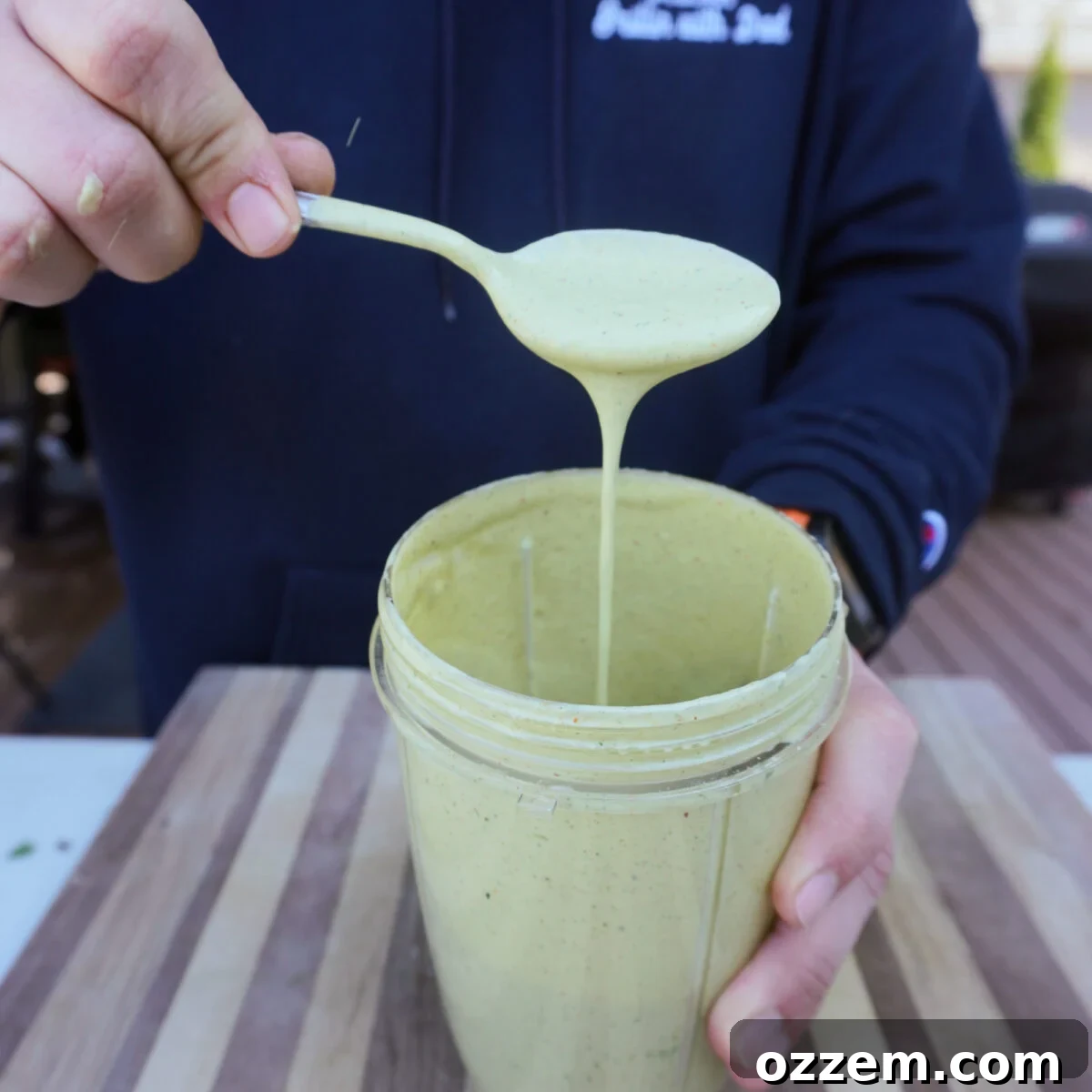 A bowl of freshly made creamy avocado and cilantro sauce, vibrant green and smooth.