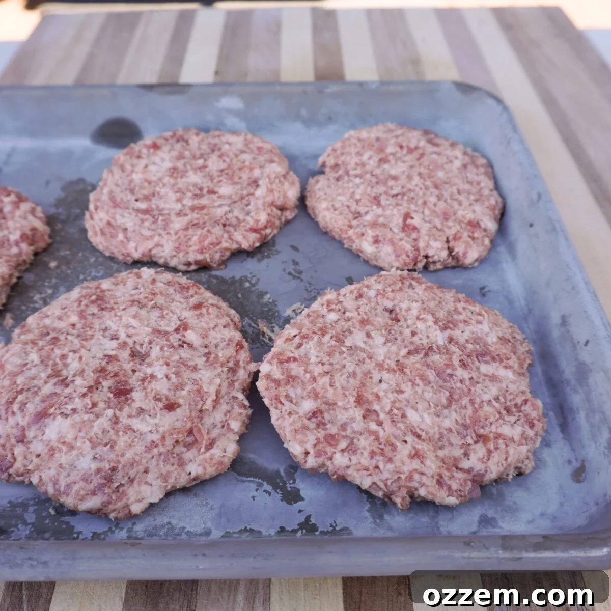 Neatly shaped raw breakfast sausage patties, ready for the griddle.