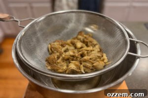 Roasted eggplant flesh in a strainer to drain excess moisture.