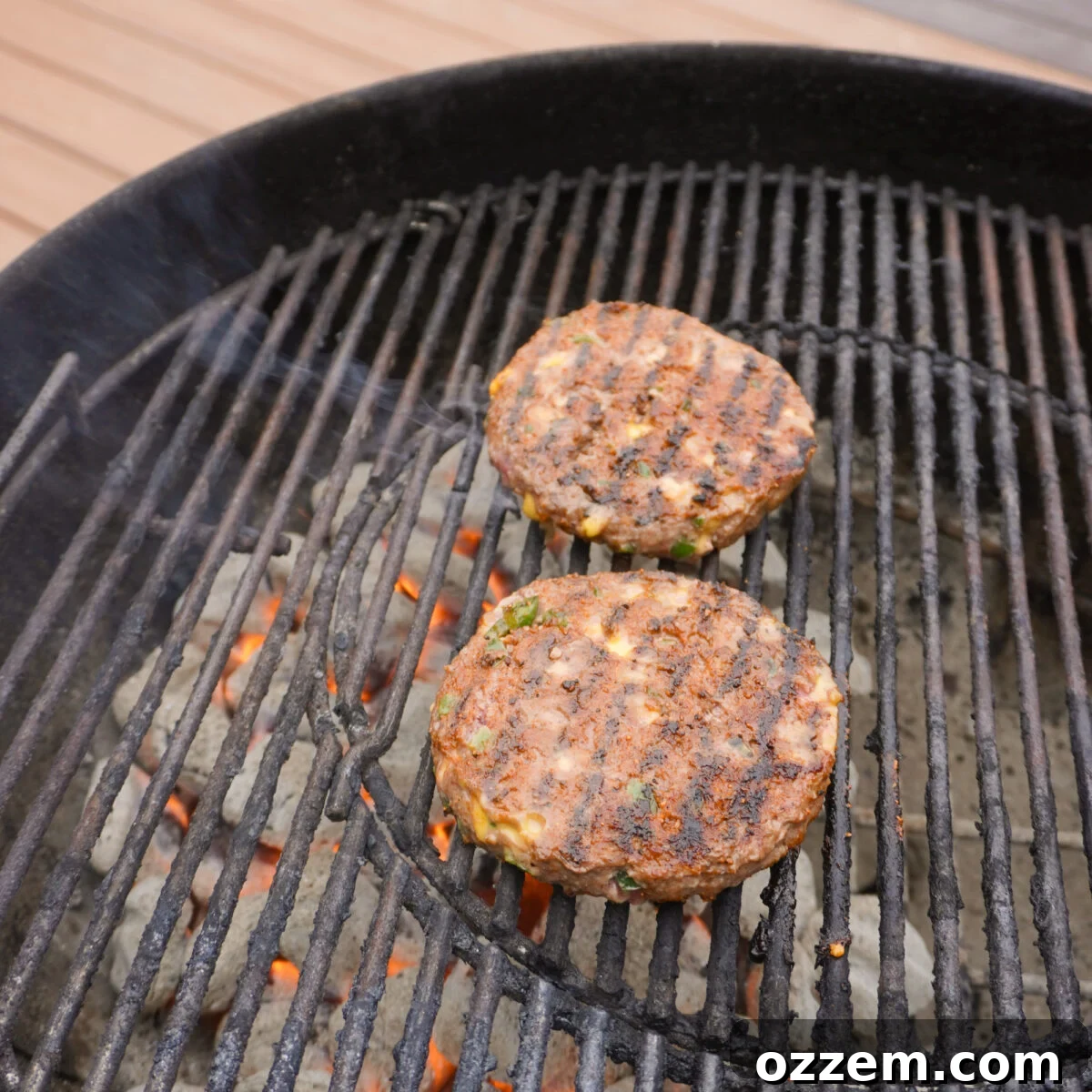 Jalapeño Popper Pub Burger Recipe: Creamy, Crispy, Spicy Bite 5 grilled jalapeno beef patties on a charcoal grill.