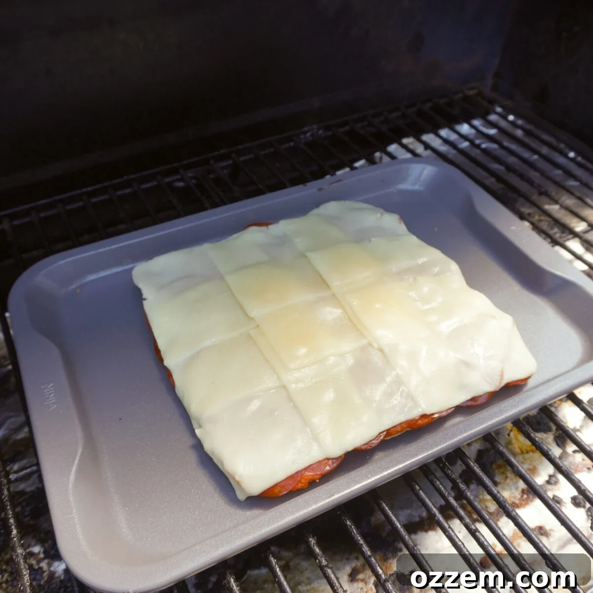 melted cheese on sliders on the grill.