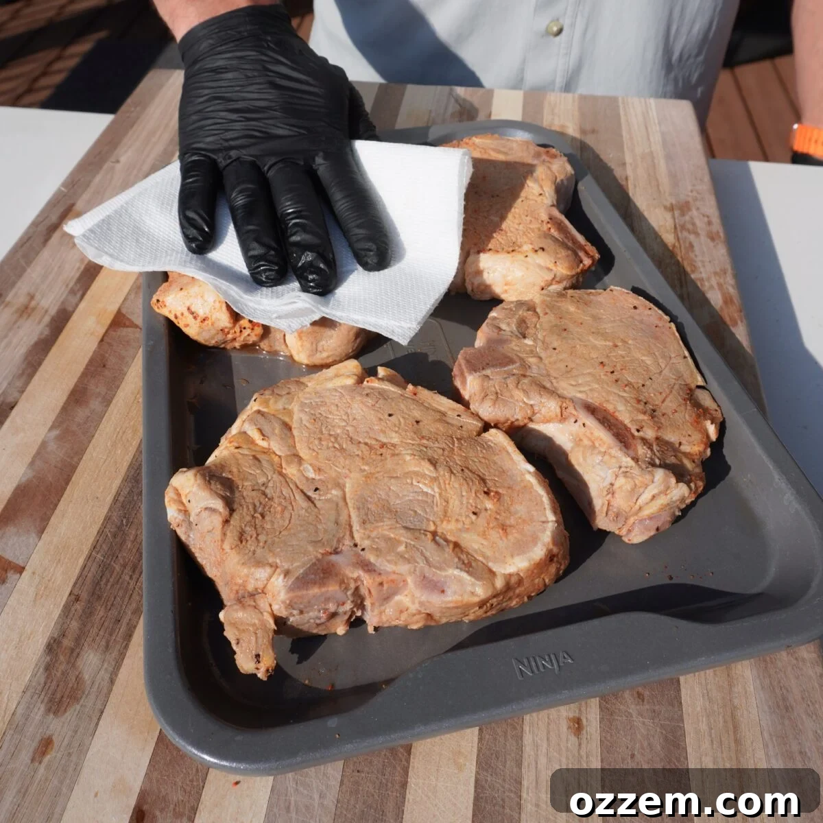 patting dry brined pork chops.