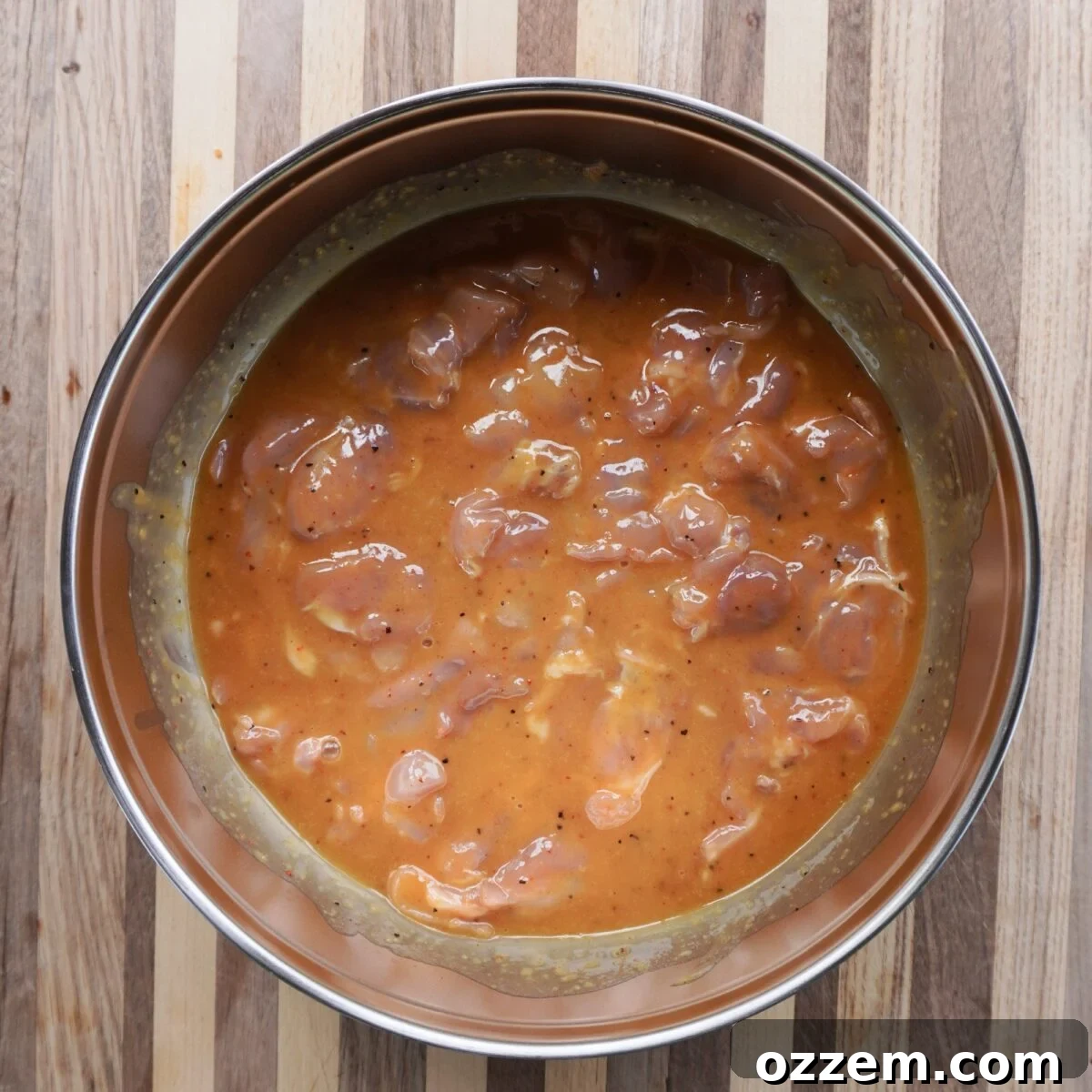 raw chicken thighs in a marinate in a large bowl.