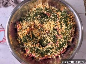 Spicy Jalapeño Cheddar Venison Snack Sticks Recipe 11 Adding jalapeños and cheddar cheese to meat in stainless mixing bowl.
