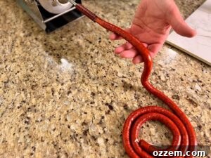 Spicy Jalapeño Cheddar Venison Snack Sticks Recipe 12 Stuffing snack sticks and coiling them on the counter.