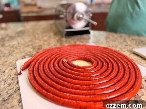 Spicy Jalapeño Cheddar Venison Snack Sticks Recipe 13 Smoked venison snack sticks stuffed and coiled on cutting counter.