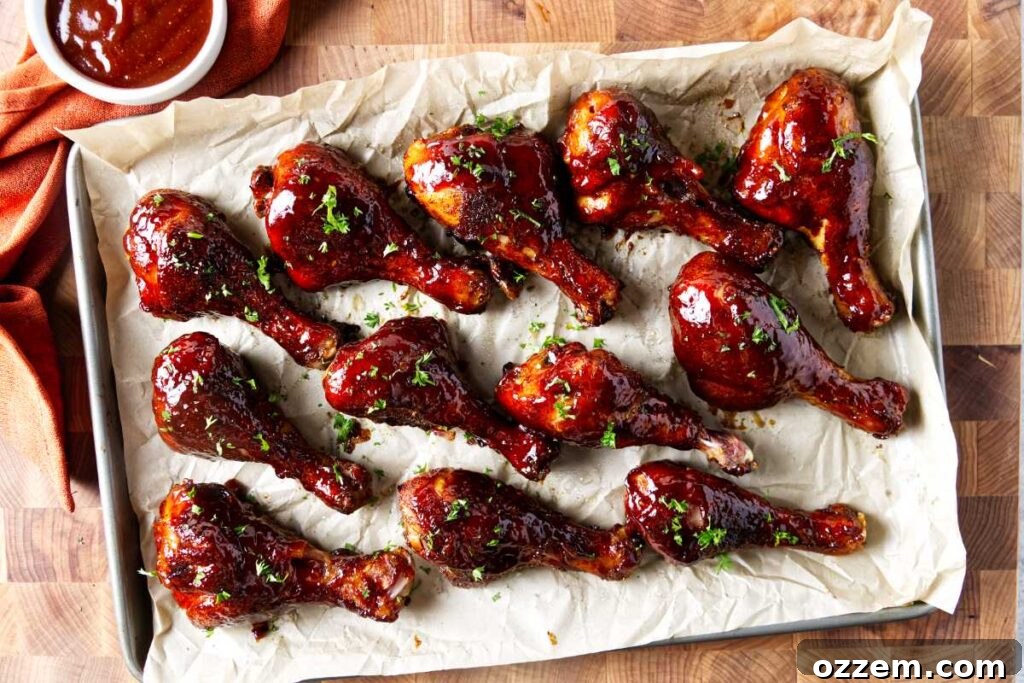 Smoked Chicken Drumsticks Recipe for Tender, Smoky Flavor 5 Several smoked chicken drumsticks on a cutting board coated in bbq sauce.