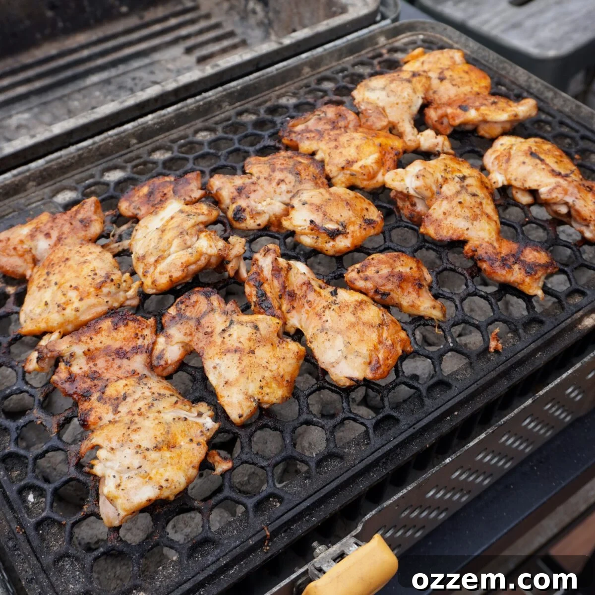 Grilled chicken thighs on a charcoal grill.