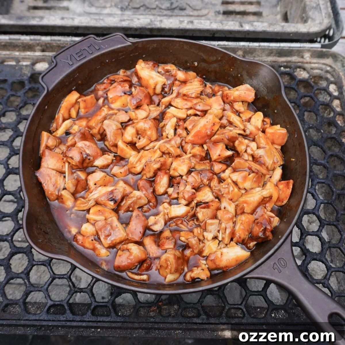Grilled bourbon chicken dish in a cast iron skillet.