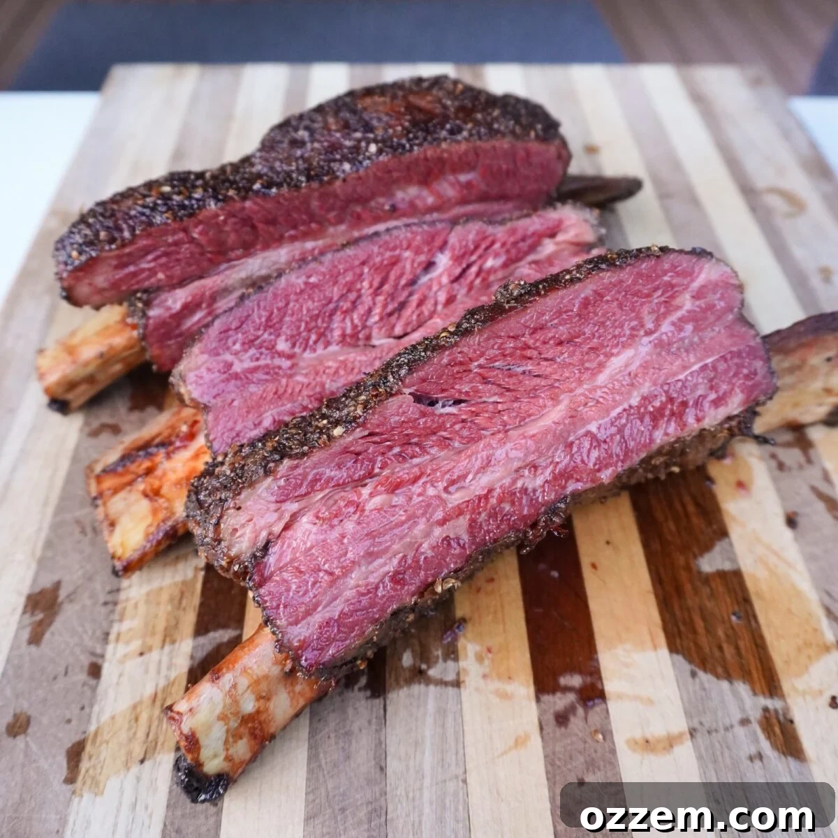Sliced Smoked Pastrami Beef Ribs on a cutting board.