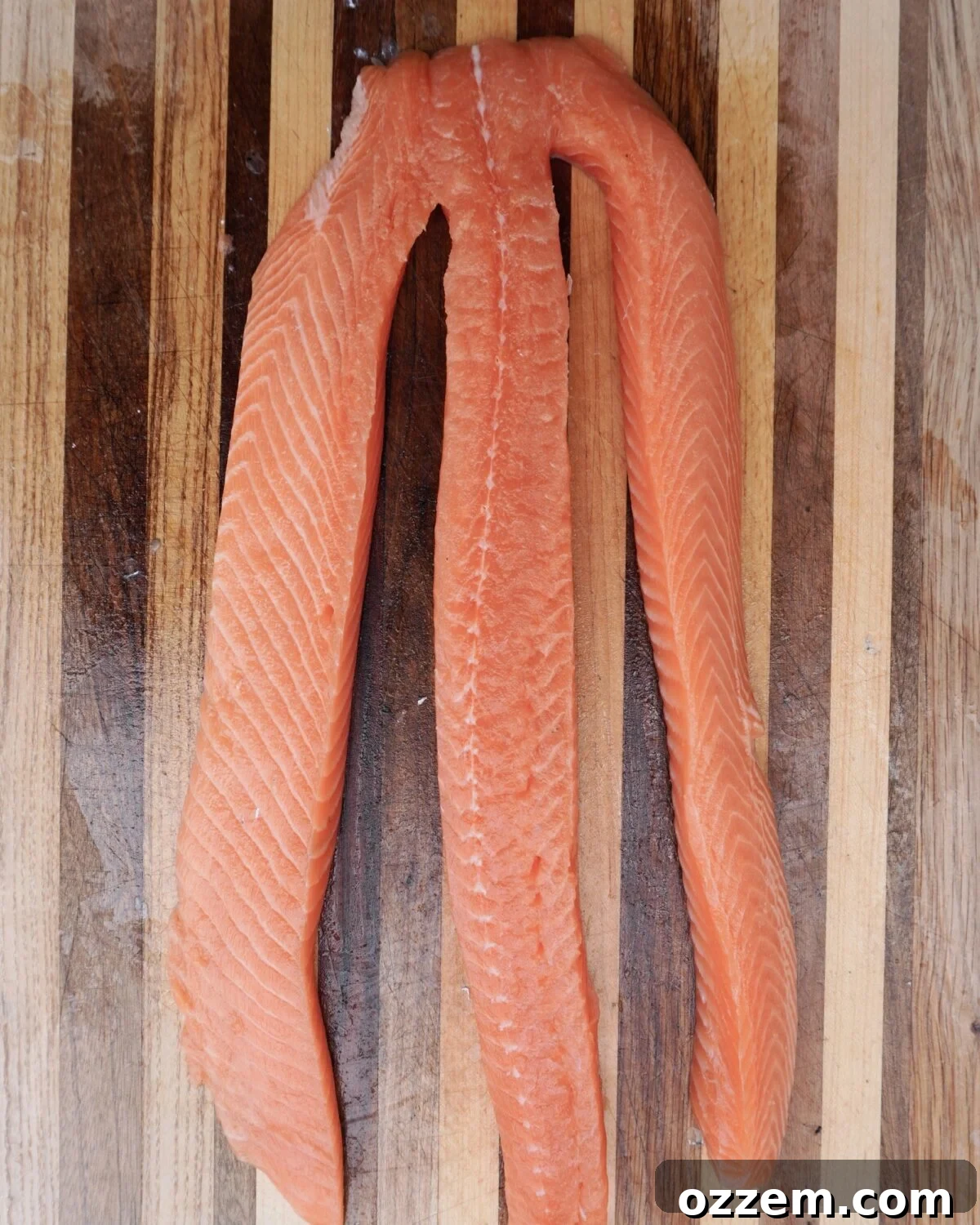 Salmon filet separate into 3 even strips.