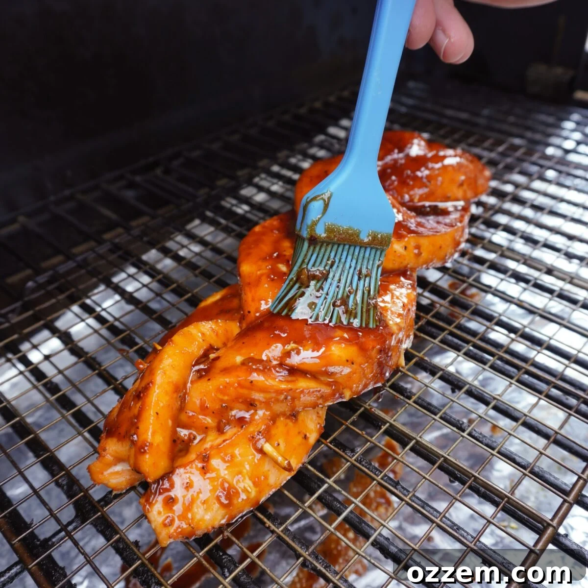 Glazing the smoked braided salmon with the sweet honey garlic glaze.