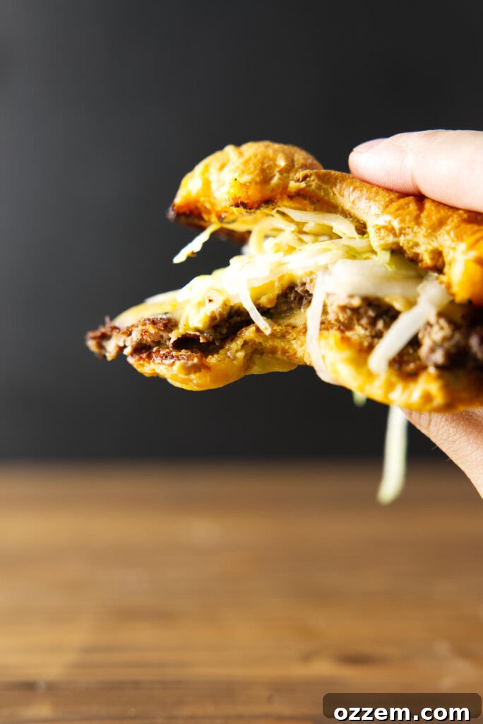 Blackstone Smash Burgers with Perfectly Crispy Edges 6 Bite taken out of burger being held by hand.