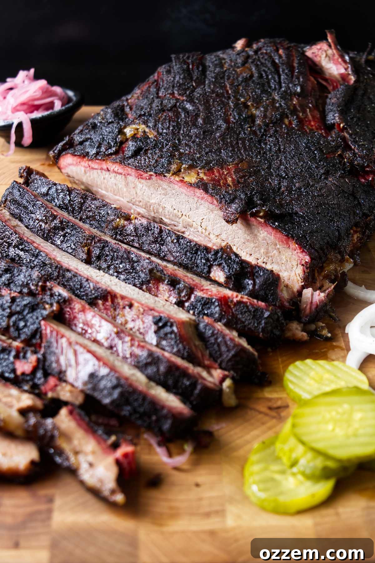 A smoked brisket on a cutting board with thick slices.