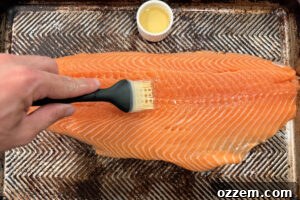 Smoky Pellet Grill Salmon Recipe 8 Brushing salmon fillet with olive oil on a sheet pan.