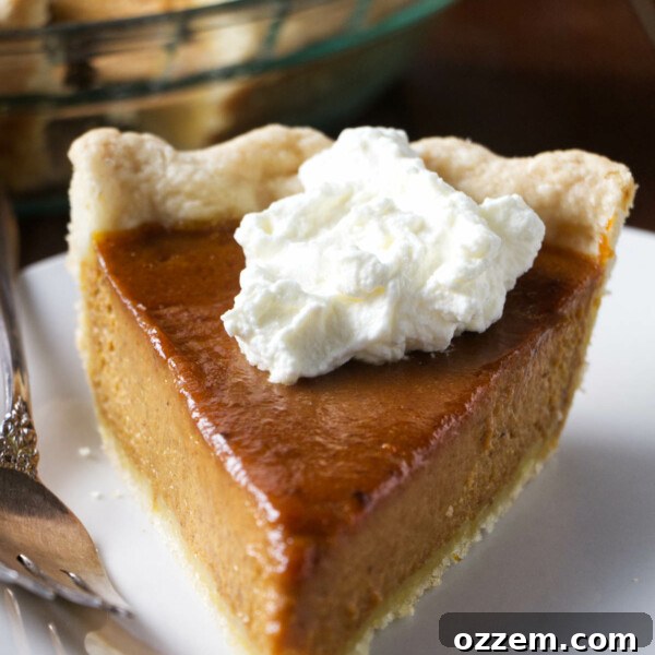 A slice of smoked pumpkin pie topped with bourbon whipped cream.