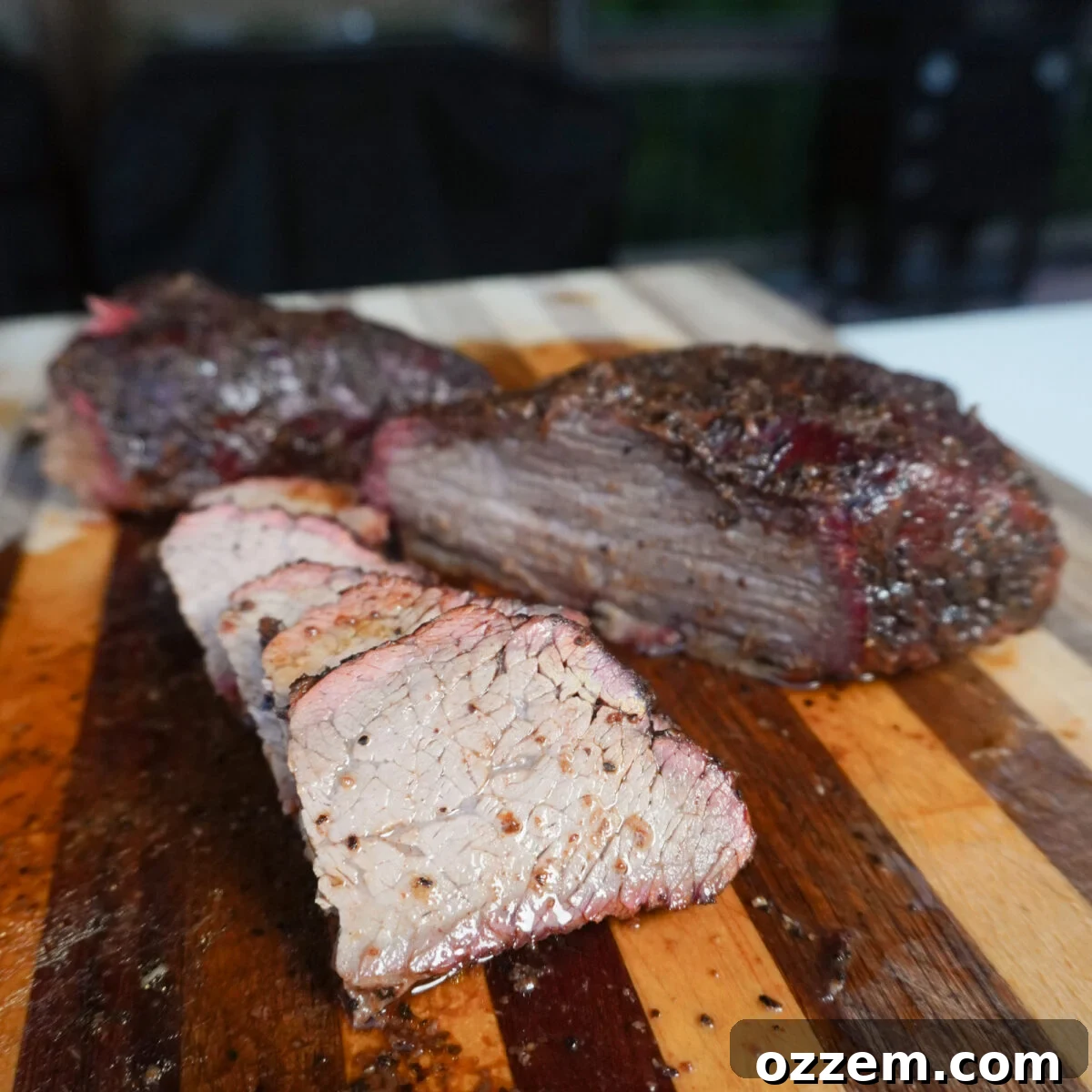 sliced brisket style smoked tri tip on cutting board.